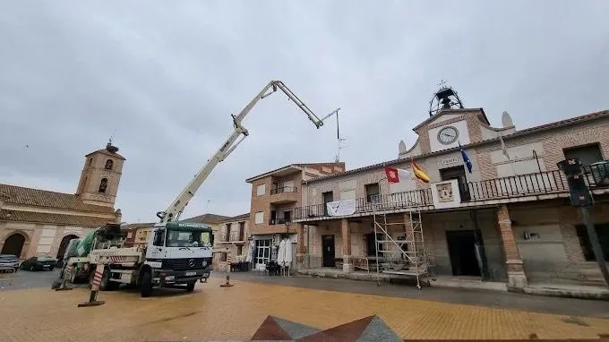 Camión de bombeo de hormigón trabajando en plaza de pueblo en Toledo